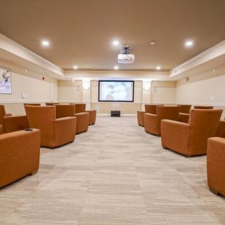 A modern theater room with plush seating and a large screen, ready for a viewing experience.