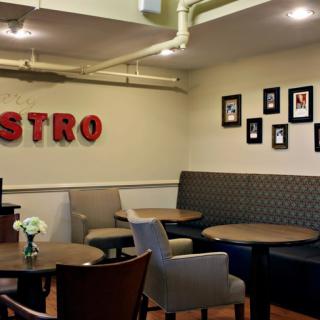 Cozy bistro interior with tables, chairs, and wall decorations.
