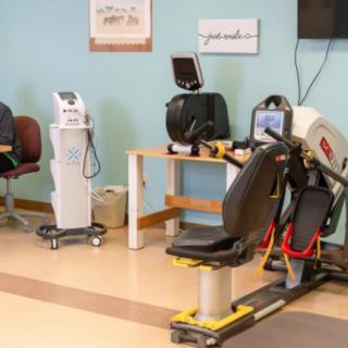 A rehabilitation room with various exercise equipment for physical therapy.