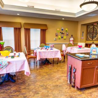 A brightly decorated room with tables and chairs set up for dining or activities.