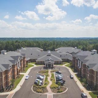 Aerial view of a suburban housing complex with well-maintained landscaping and parking areas.
