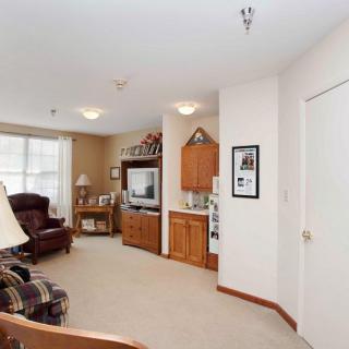 A cozy living room featuring a television, sofa, and wooden cabinet with warm lighting.