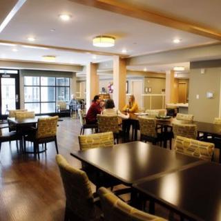 A cozy dining area with tables and chairs, featuring two people engaged in conversation.