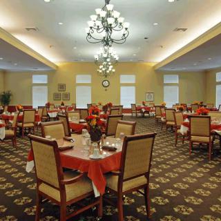 A formal dining room with elegantly set tables and a chandelier.