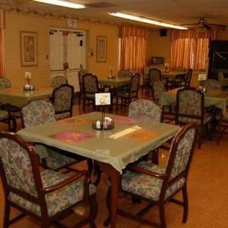 A cozy dining area with tables and chairs set for guests.