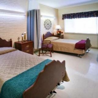 A cozy bedroom with two single beds, bedside tables, and a window letting in natural light.