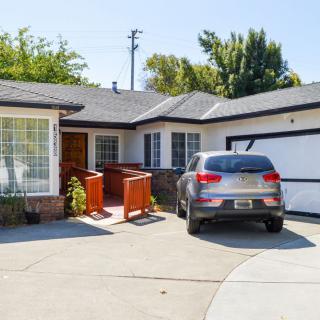 A suburban house with a car parked in the driveway.