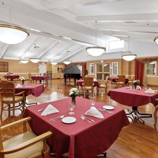 An elegant dining area with red tablecloths and arranged settings in a spacious restaurant.