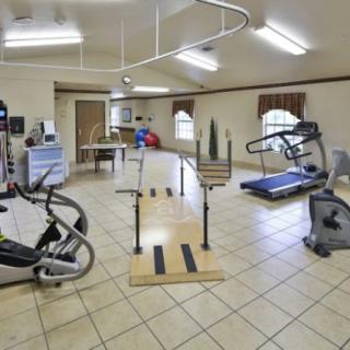 A fitness room equipped with various exercise machines and rehabilitation equipment.