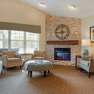 A cozy living room with a stone fireplace, ample seating, and plenty of natural light.