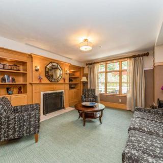 A cozy living room featuring a fireplace, built-in bookshelves, and comfortable seating.