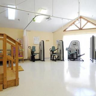 A spacious gym area equipped with various exercise machines, ideal for fitness and rehabilitation activities.