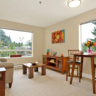 A cozy living room with large windows and wooden furniture.