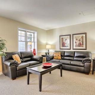A cozy living room featuring black leather sofas and a central coffee table.