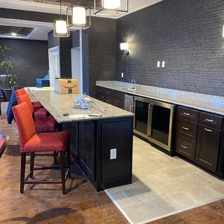 A modern kitchen interior with a sleek countertop and vibrant red bar stools.