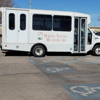 A healthcare bus parked in a designated handicap parking space.