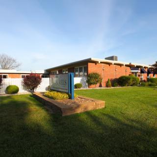 A well-maintained building surrounded by green grass and shrubbery.
