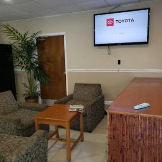 A cozy waiting area featuring comfortable seating and a TV screen.