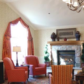 A cozy living room featuring a fireplace, comfortable chairs, and elegant decor.