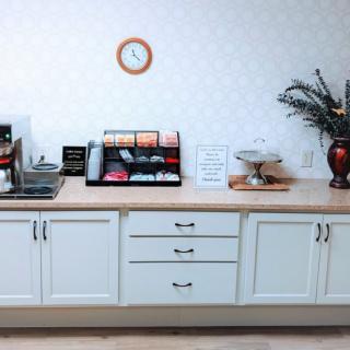 A neatly organized coffee station with a selection of snacks and beverages on a kitchen counter.