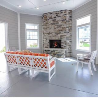 A cozy living room with a stone fireplace and bright windows.