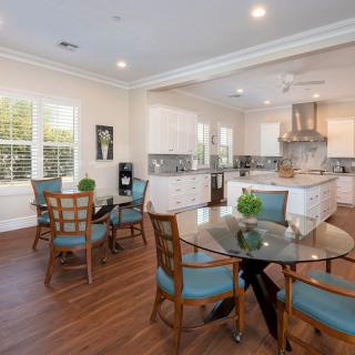 A modern kitchen and dining area with wood flooring and bright lighting.