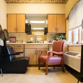 A cozy hair salon waiting area featuring a mix of seating and functional space.