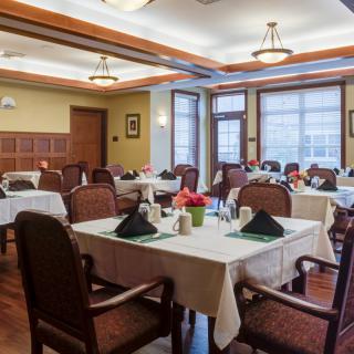 A well-decorated dining room with neatly arranged tables and chairs.