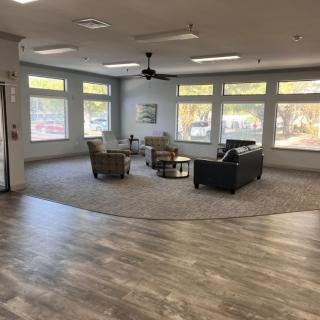 A modern living room with ample natural light, featuring comfortable seating and a neutral color palette.