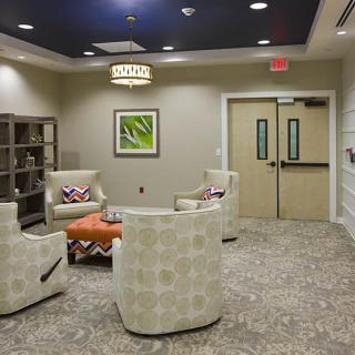 A modern waiting room featuring comfortable seating, stylish furniture, and contemporary artwork.