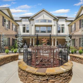 A beautifully designed building with a gated courtyard and elegant landscaping.