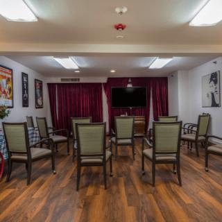 A small meeting room with arranged chairs facing a television.