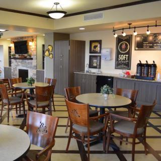 A cozy cafe interior with tables, chairs, and a coffee station.
