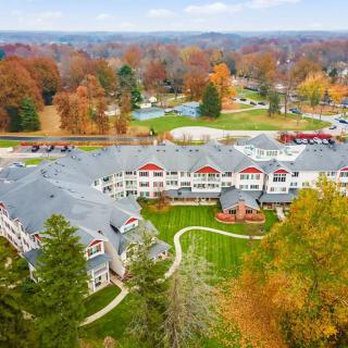Aerial view of a residential building surrounded by colorful autumn trees.