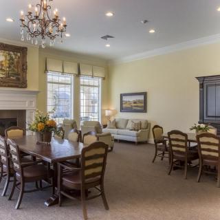 A cozy dining room with elegant furniture and a chandelier.