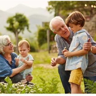 A joyful moment with grandparents and children enjoying time together in a garden.