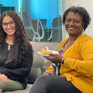 Two women enjoying a moment together in an office environment.