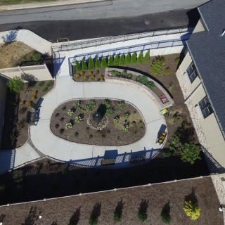 An aerial view of a landscaped garden with pathways adjacent to a building.