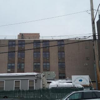 A view of a multi-story building against a cloudy sky, showcasing urban architecture and infrastructure.