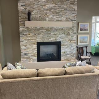 A cozy living room featuring a stone fireplace and comfortable sofa.