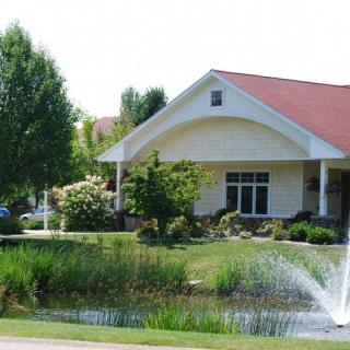 A charming house with a well-maintained garden and pond featuring a fountain.