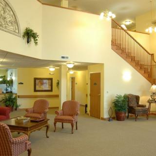 A cozy lobby area featuring comfortable seating and a staircase.