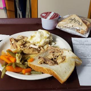 A meal consisting of chicken, mashed potatoes, mixed vegetables, a sandwich, and dessert.
