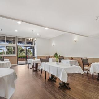 A modern restaurant interior with neatly arranged tables and chairs, ready for guests.