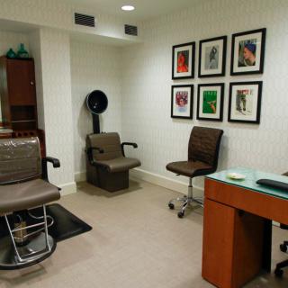 Modern hair salon interior with chairs and wall artwork.
