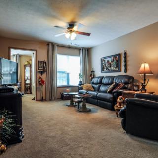 A cozy living room with a comfortable sofa, television, and warm lighting.