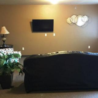 A cozy living room with a sofa facing a wall-mounted TV and decorative elements.