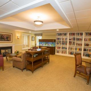 A cozy living room with bookshelves, an aquarium, and comfortable seating.