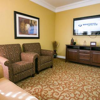 A cozy living room with armchairs, a television, and decor.