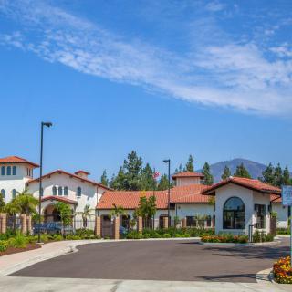 A scenic view of a residential building complex with red-tiled roofs against a clear blue sky.